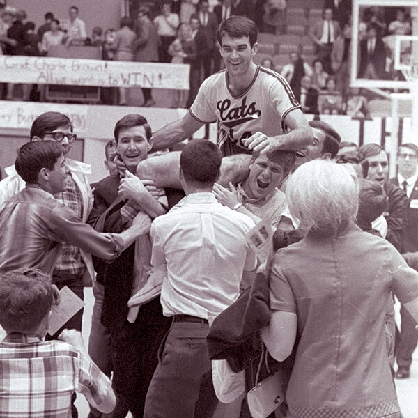 John Ray Godfrey (’68) is carried off the court by fans after setting a single-game scoring record in the first basketball game played in Moody Coliseum in 1968.