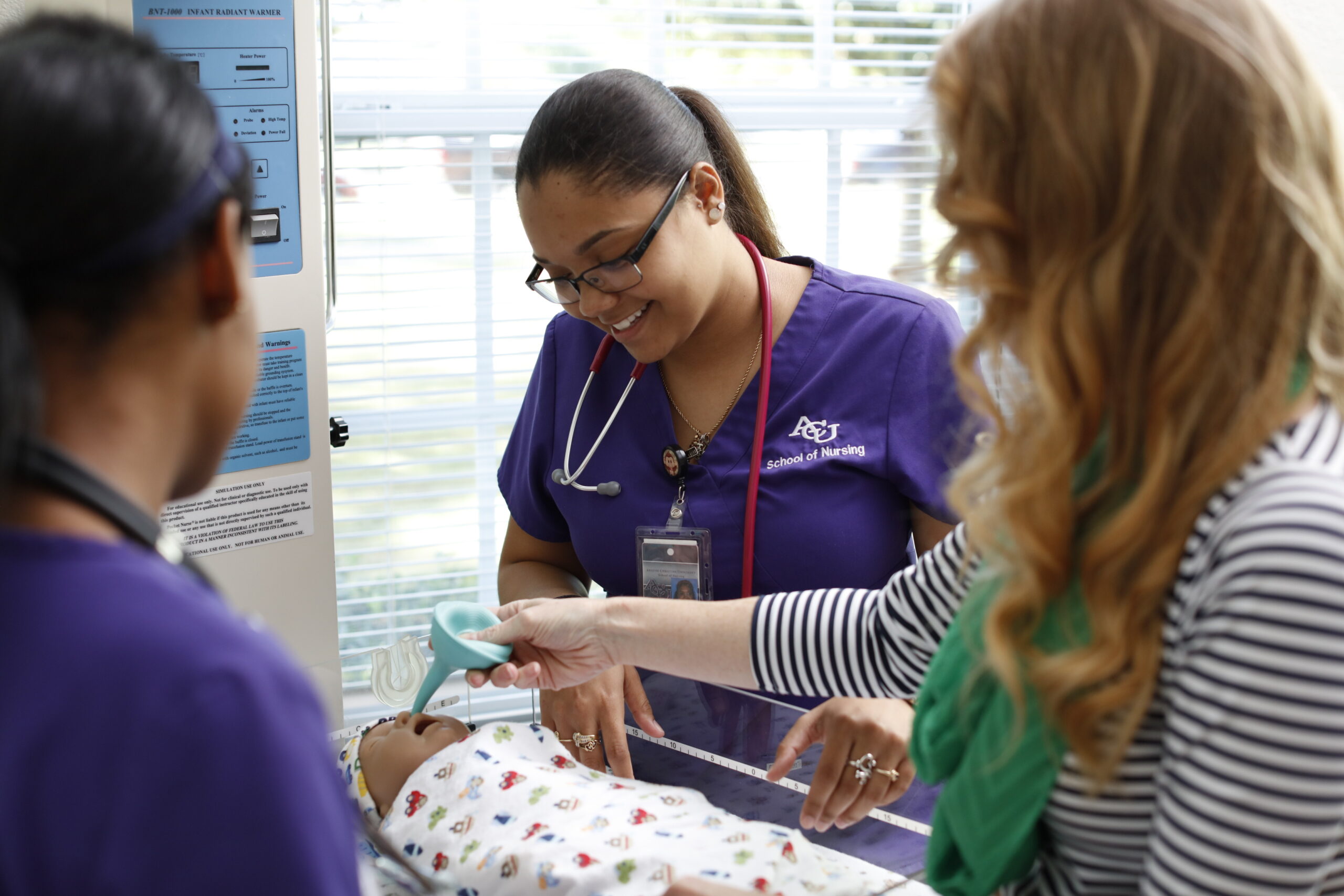ACU nursing students learning how to provide health care to an infant