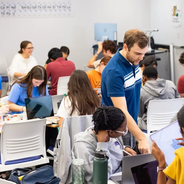 A professor walks around helping students during a chemistry class.