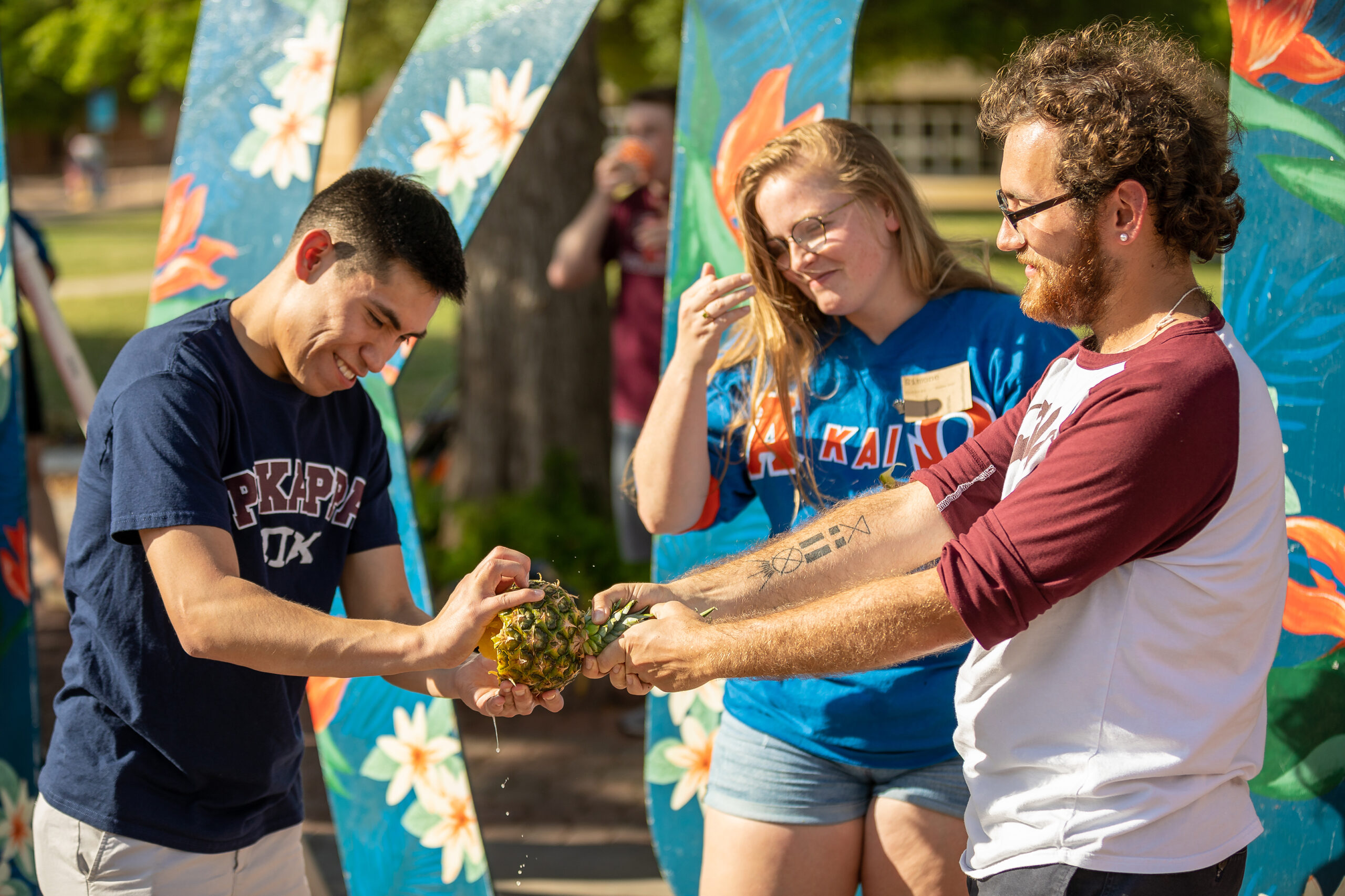 Two students holding a pineapple