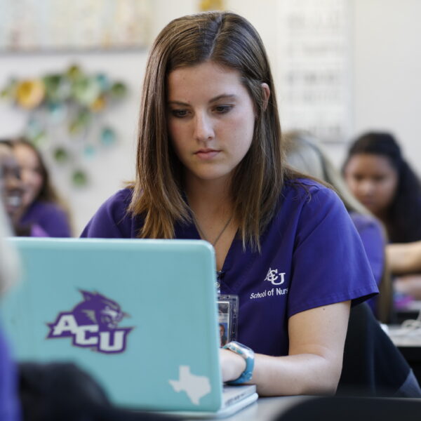 an ACU undergraduate student taking notes on her laptop