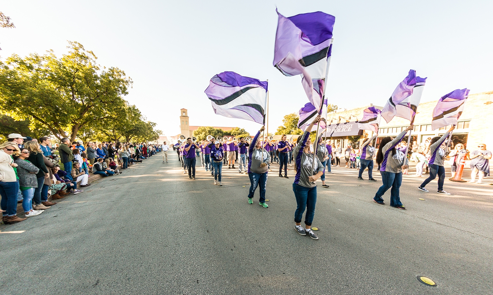 Students in a parade waving ACU flags