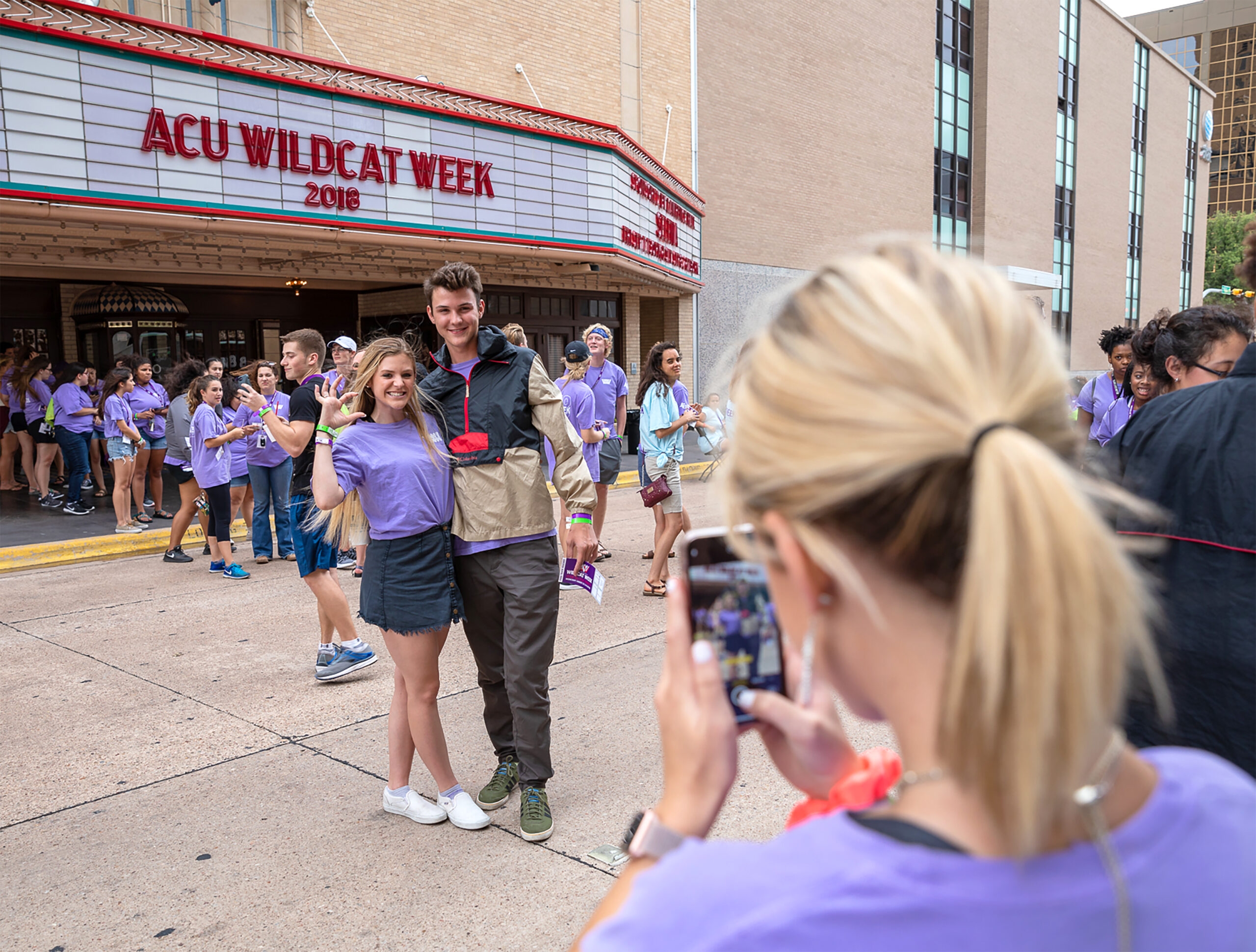 Students taking a picture outside of a theater at the ACU Wildcat Week