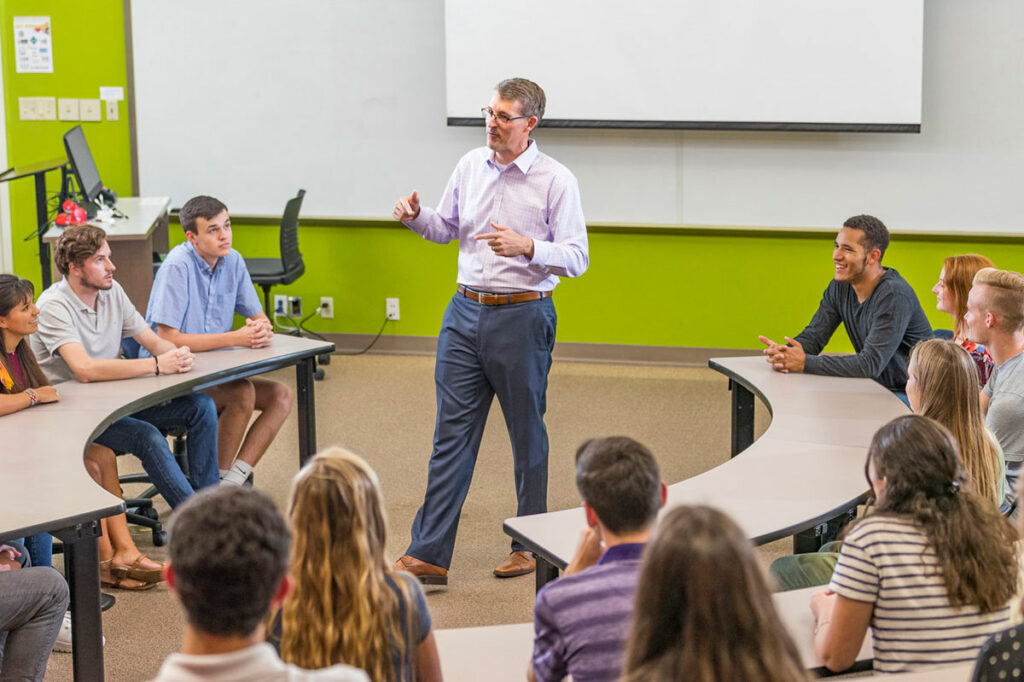 Professor talking with students in a classroom