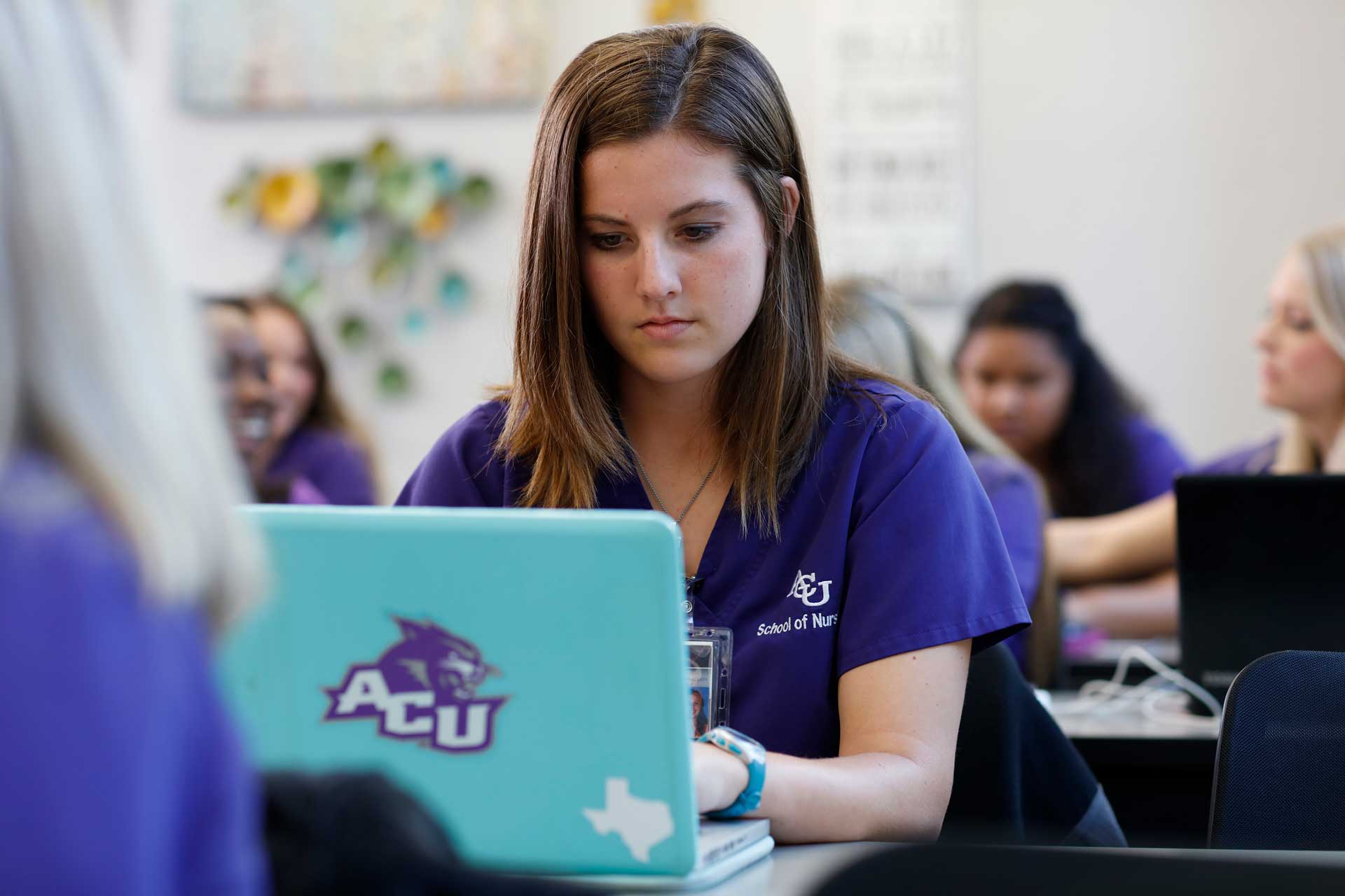 An ACU graduate student taking online classes on her laptop with other students