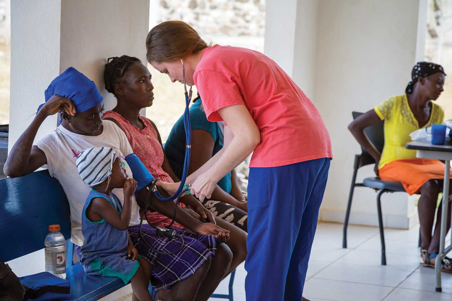 young female student treating patients on mission trip