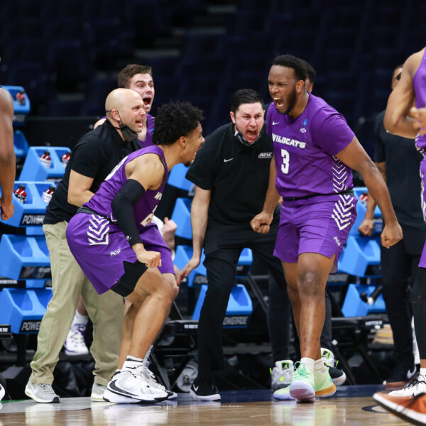 Joe Pleasant, whose two late free throws and stolen pass sealed ACU’s upset win over Texas, leaps with joy while leading teammates off Unity Court at Lucas Oil Stadium in Indianapolis during the NCAA Tournament.