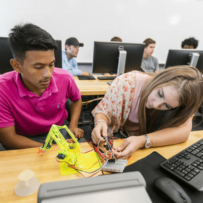2 ACU engineering students working on a robot
