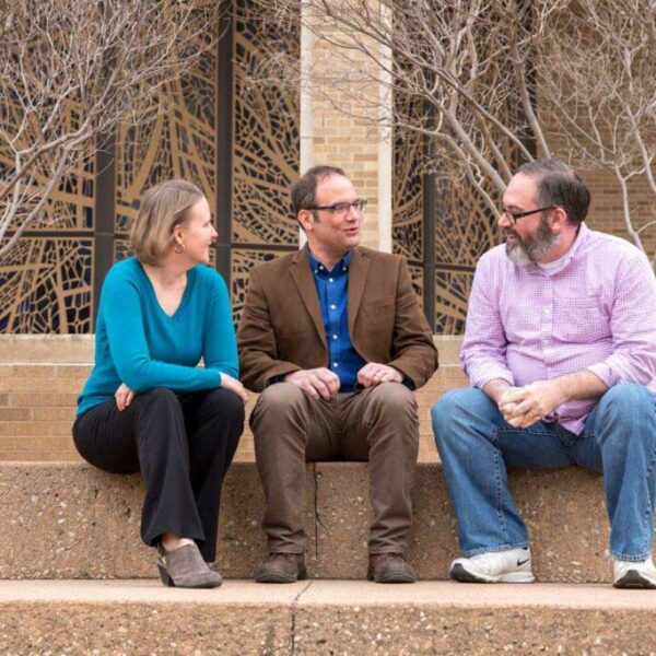ACU students sitting on steps outside building talking to a faculty member