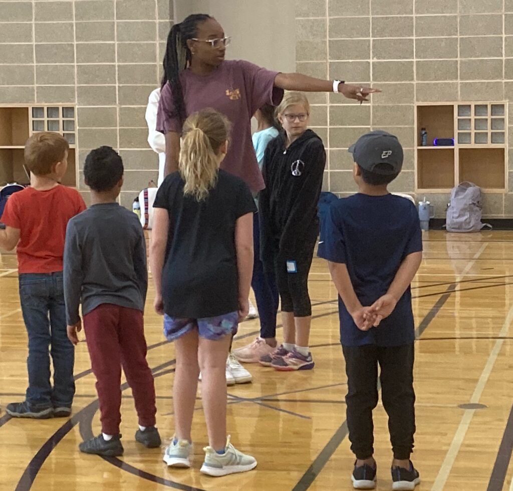 Teacher education major directs students in P.E. lesson.