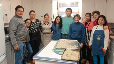 ACU International Student group shot in a kitchen with Chinese pao