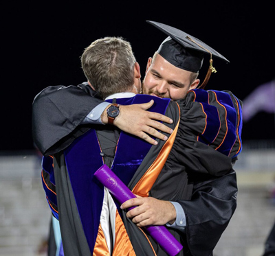 ACU graduate hugs president at commencement