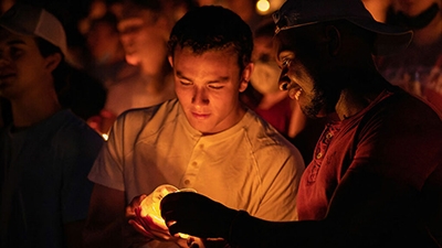 Students lighting candles at ACU Candlelight Devo event