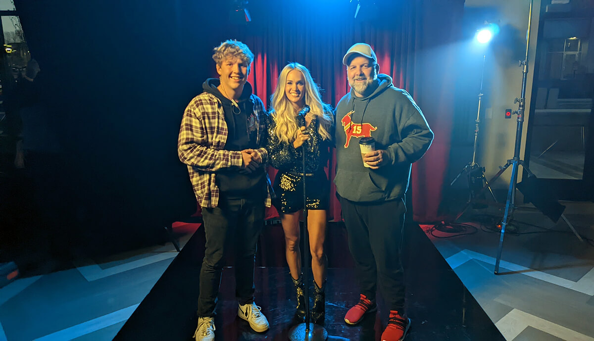 Randy Brewer (right) and his son, Jackson, on the set with Carrie Underwood during the making of a BODYARMOR sports drink commercial.