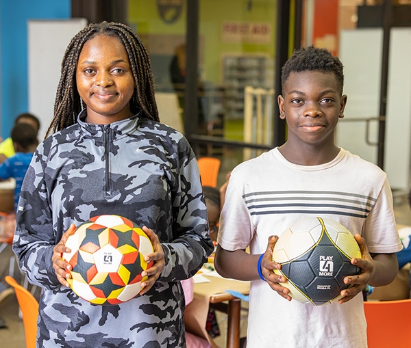Students pose with soccer balls they designed.