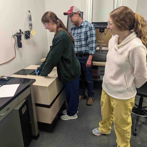 Students in the Department of Chemistry and Biochemistry working with an NMR to receive a closer look at molecular structures.