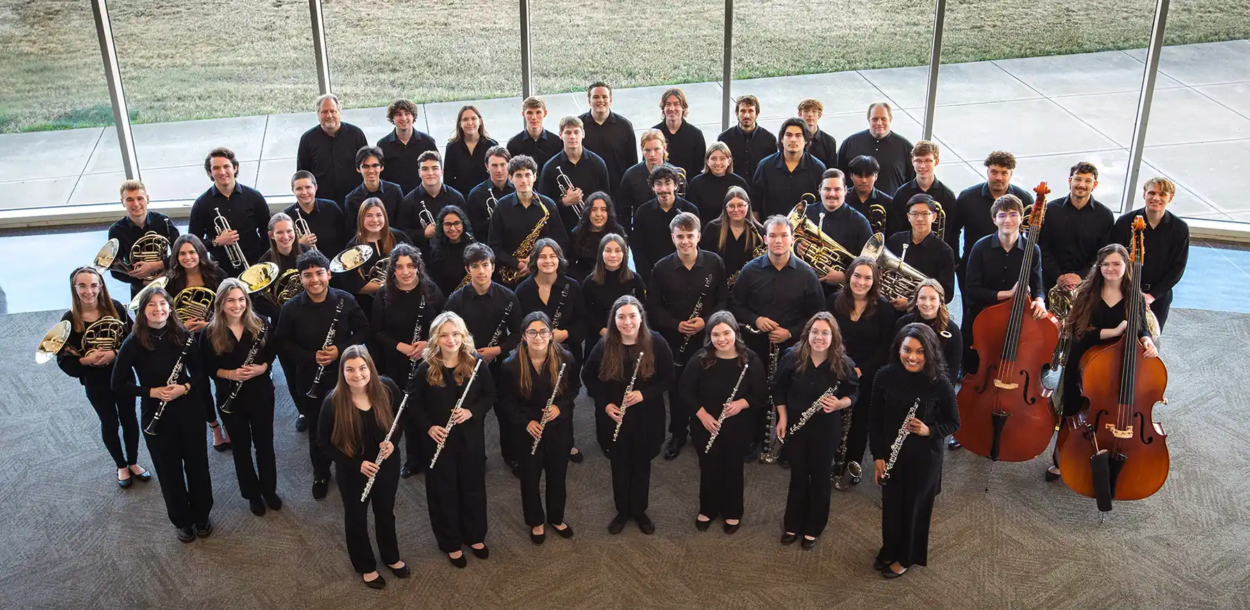 The 2026 wind ensemble poses with their instruments.
