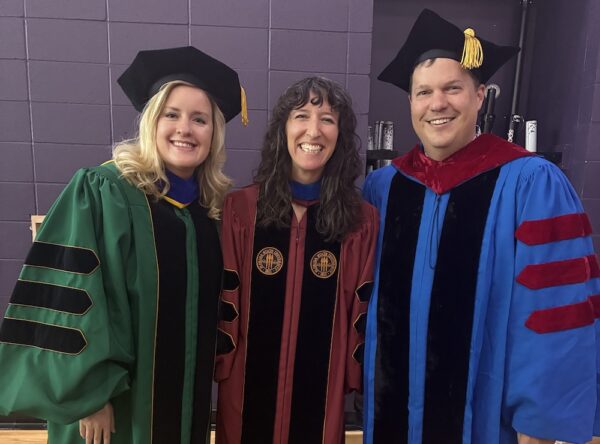 Three faculty members dressed in thier regalia.