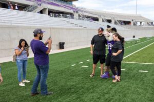 taking photos on ACU field with Willie the Wildcat