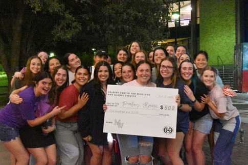The sorority of Tri Kappa Gamma with the check for Palm House, the non-profit the club supports. 