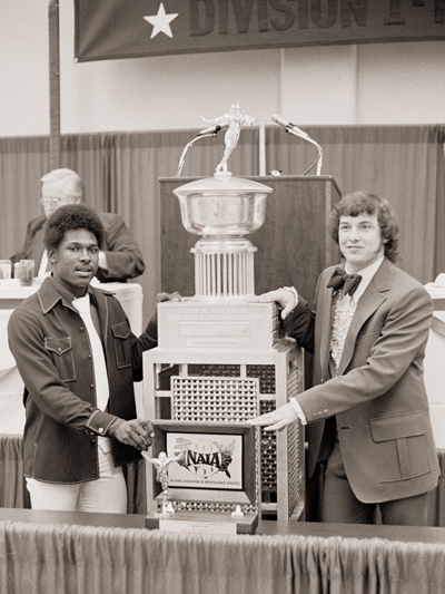 Wilbert Montgomery (left) and Clint Longley pose with the 1973 NAIA national championship trophy.