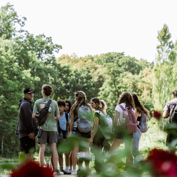 Students with backpacks standing among trees