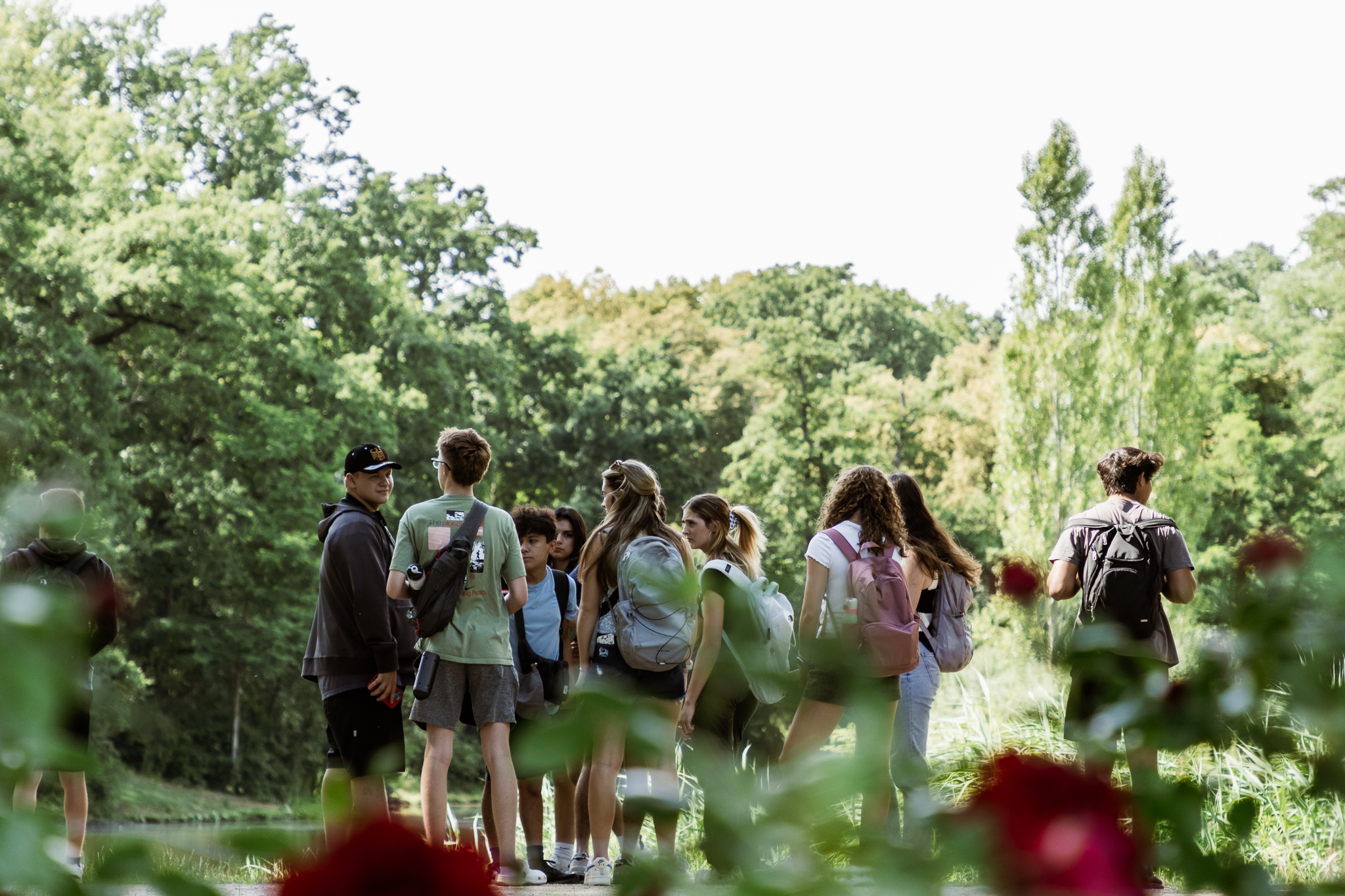 Students with backpacks standing among trees
