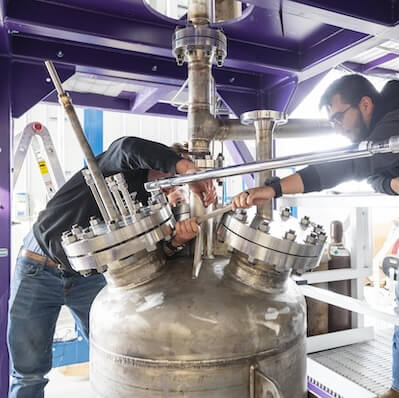 Two students working on a machine.