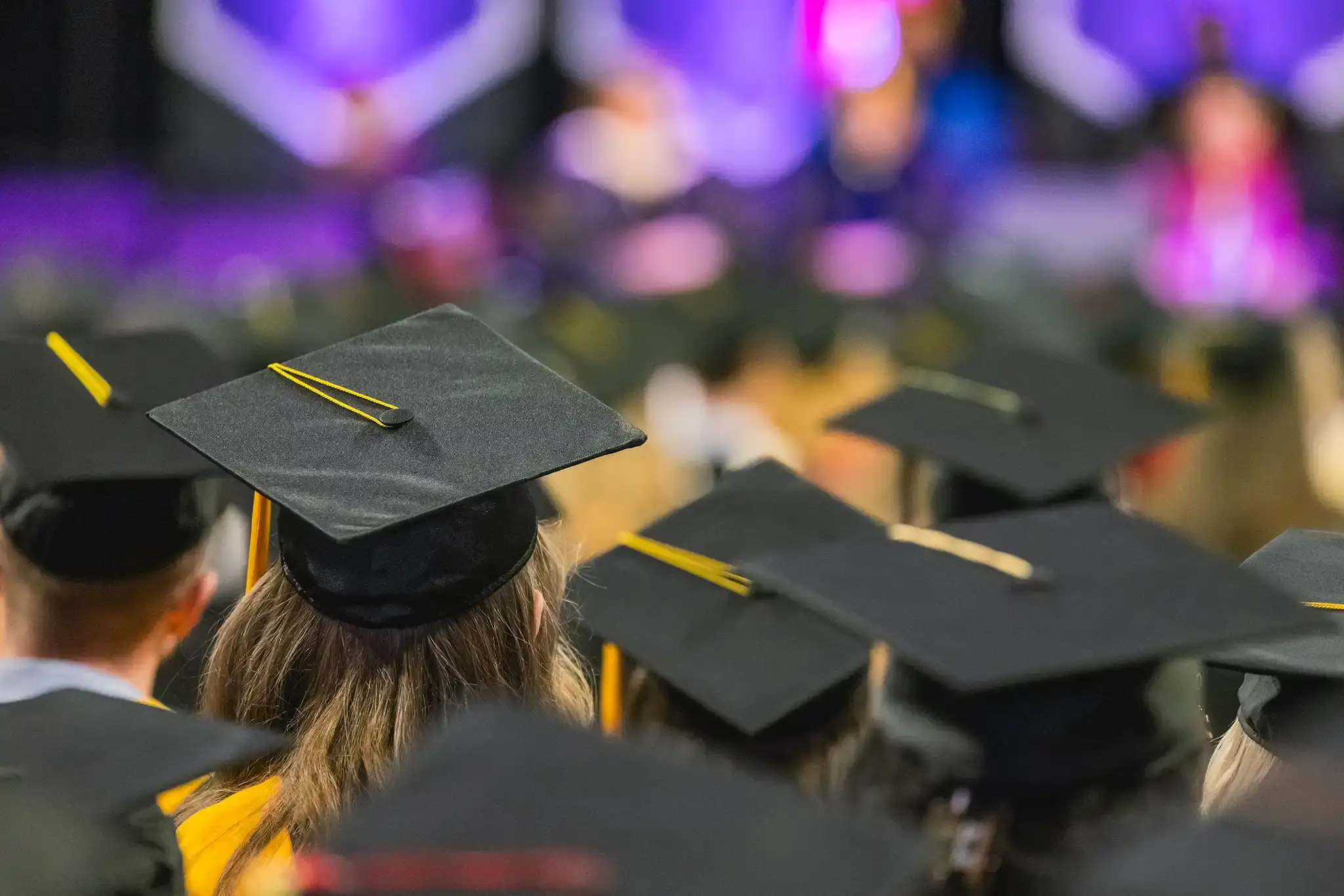 Graduates listen to a speaker at commencement.