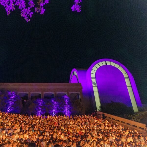 Chapel on the Hill light by purple lights with students during a candle light devotional at night.