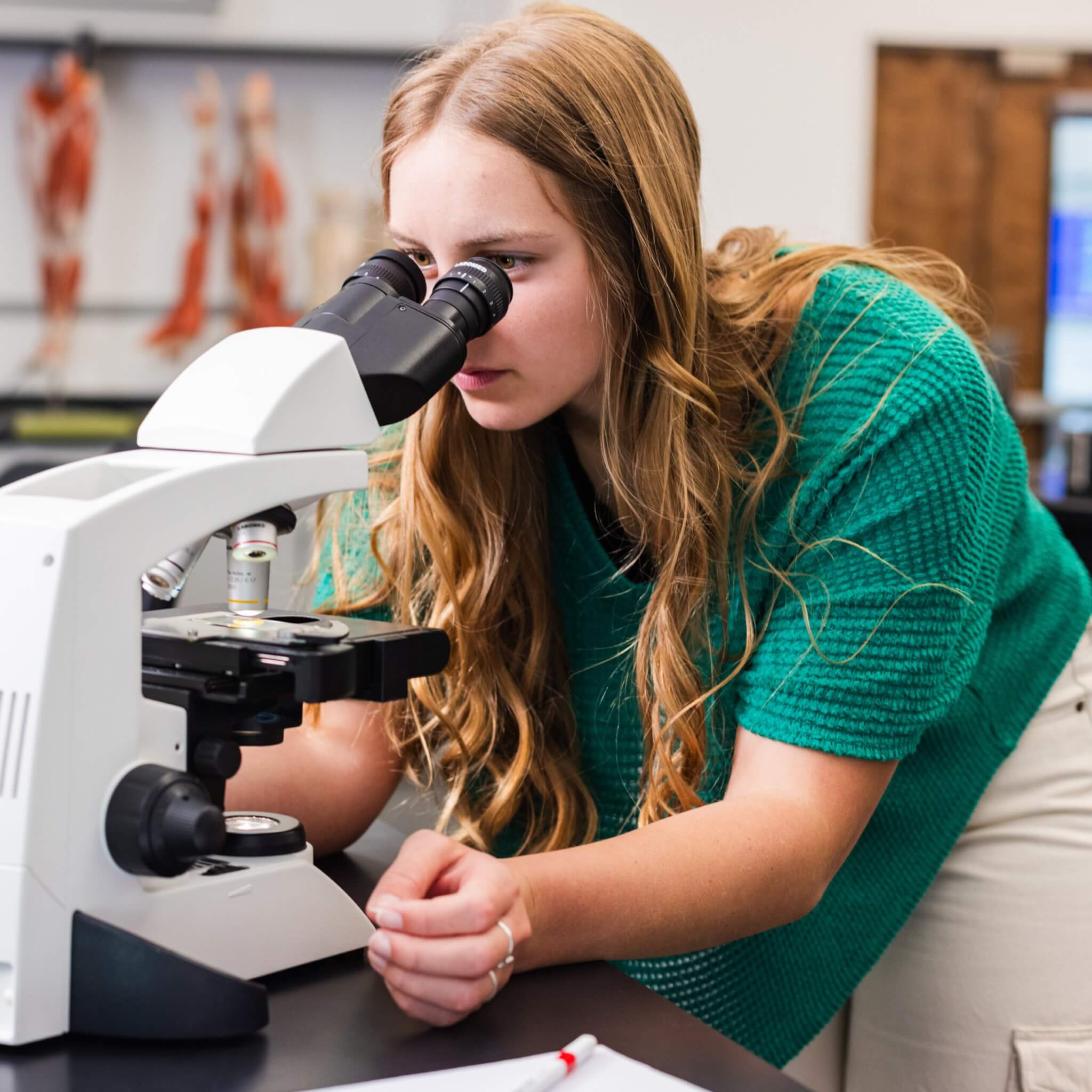 A student looking through a microscope.