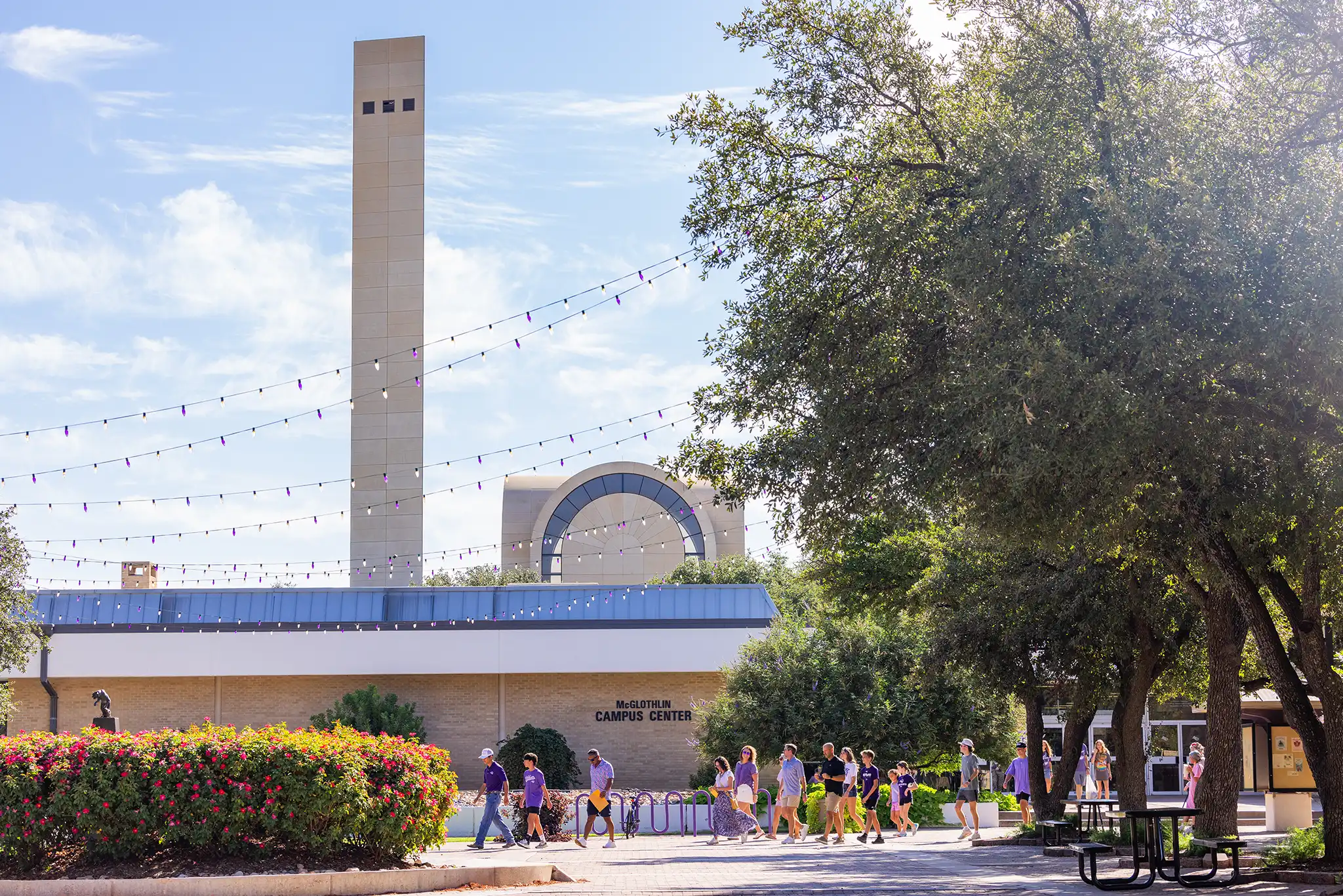 A group walks in front of the Campus Center during a campus visit tour.