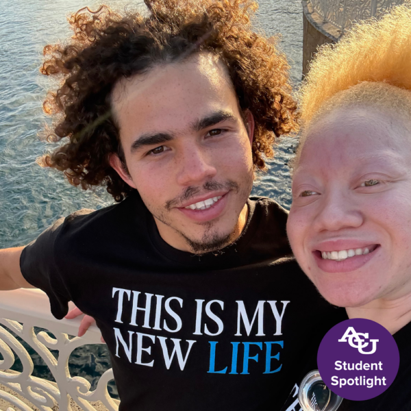Elajah Williams smiling with loved on by the water.