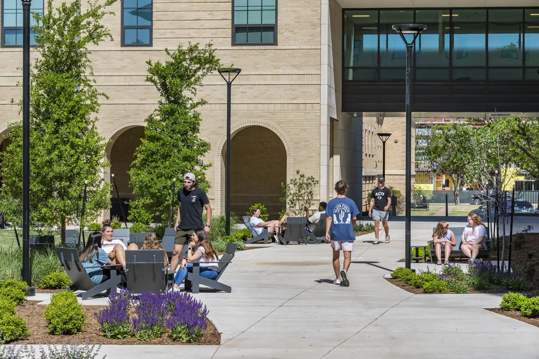 Students enjoy a sunny day on the patio outside a residence hall.