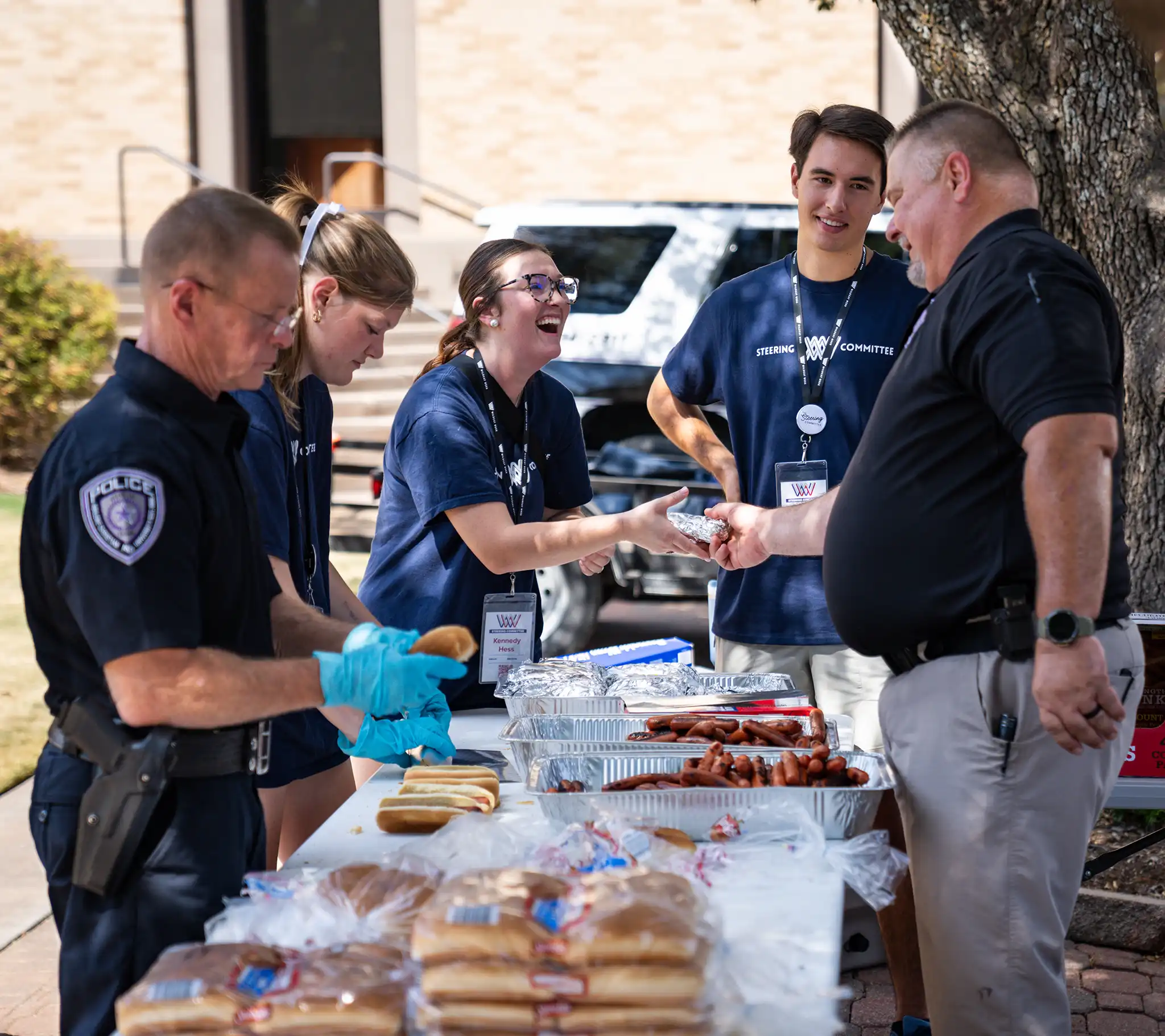 Students grab hot dogs at a police department cookout. 