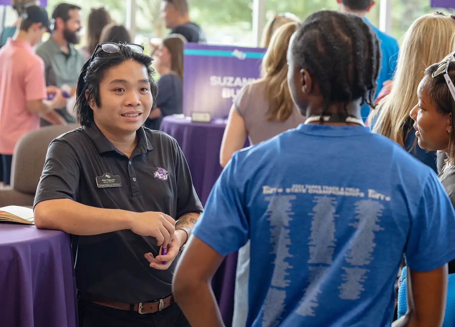 An Admissions Counselor speaks with visitors at a Preview Day event.