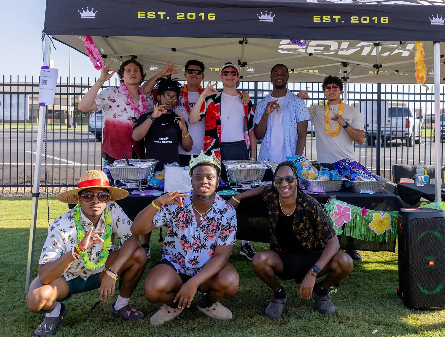 Members pose for a photo during a tailgate at the Nu Kappa Psi tent.