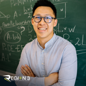 Teacher smiling in front of chalk board