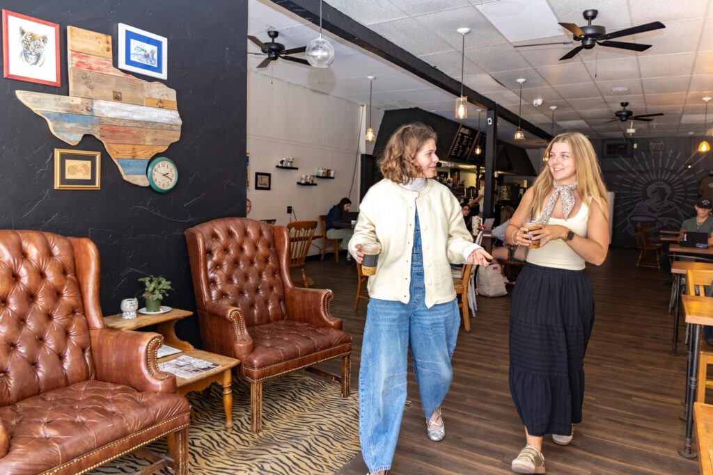students walking and talking to each other at monks coffee shop in downtown abilene.