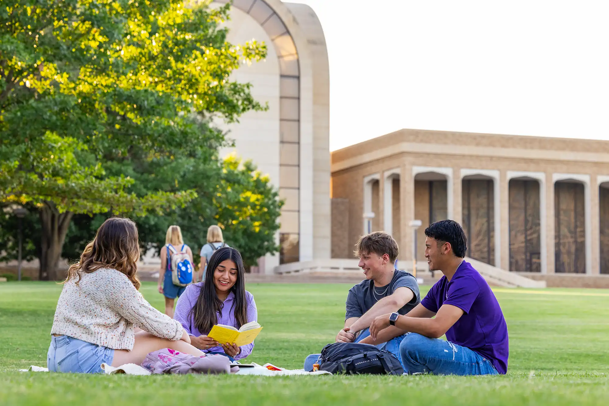 Students studying on the lawn by the Bible building.