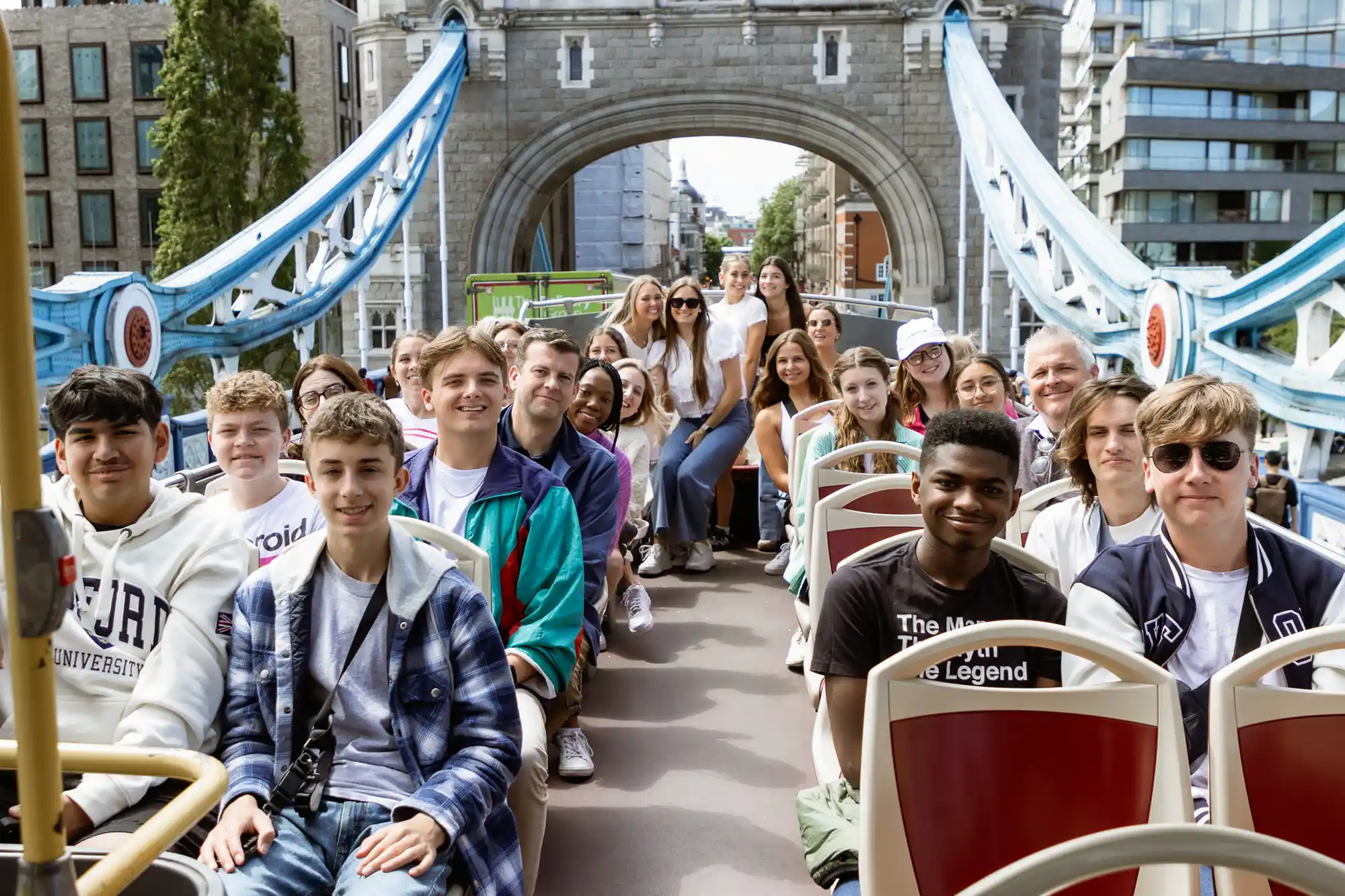 Rising Scholars students pose for a pic on top of a double-decker bus.