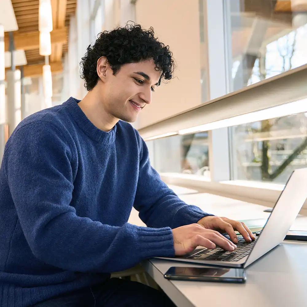 A young student works on a laptop.