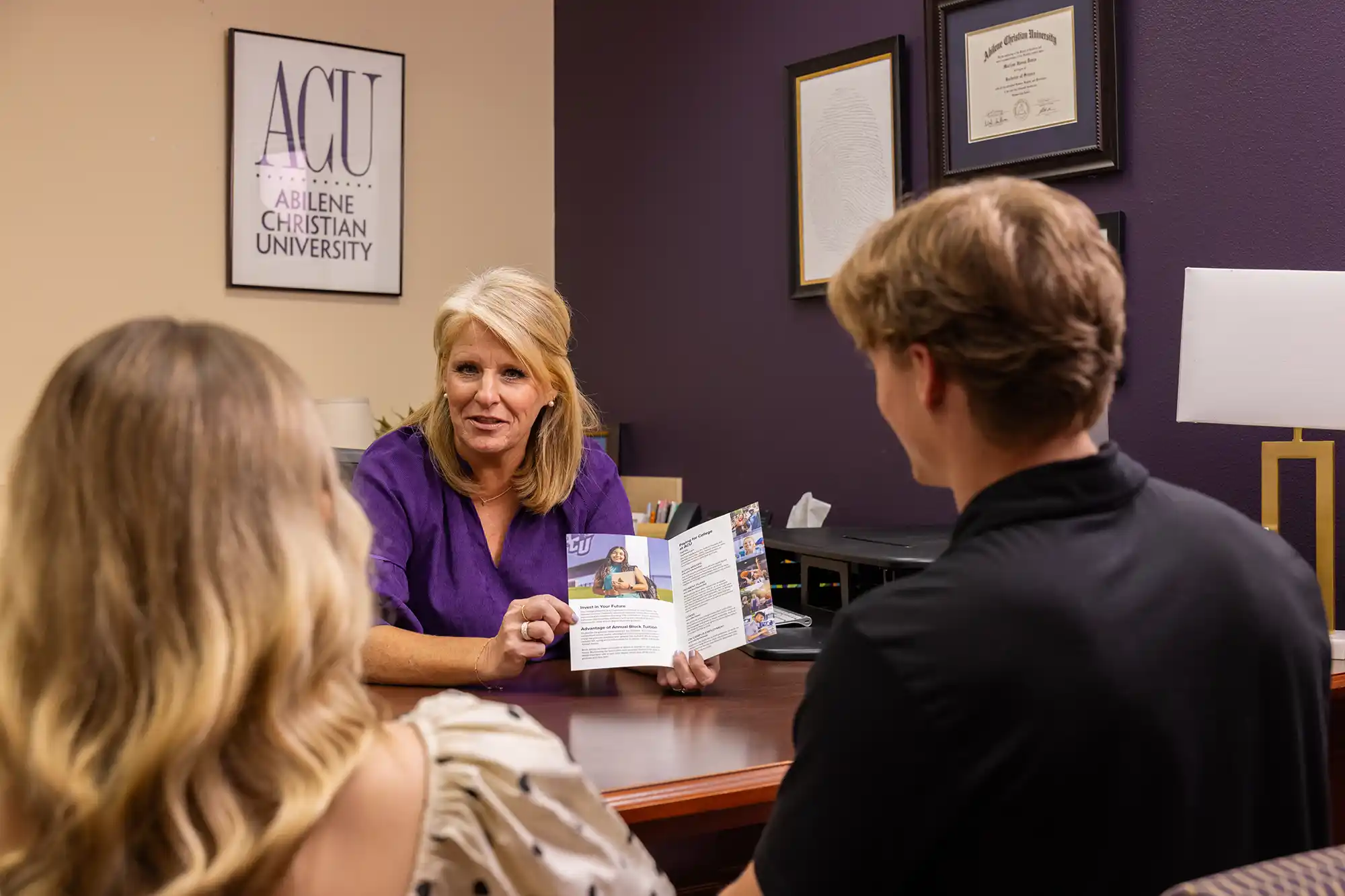 An admissions counselor speaking with interested students.