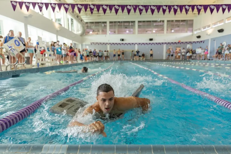 New students race in a swimming pool and compete in group events during Wildcat Week.