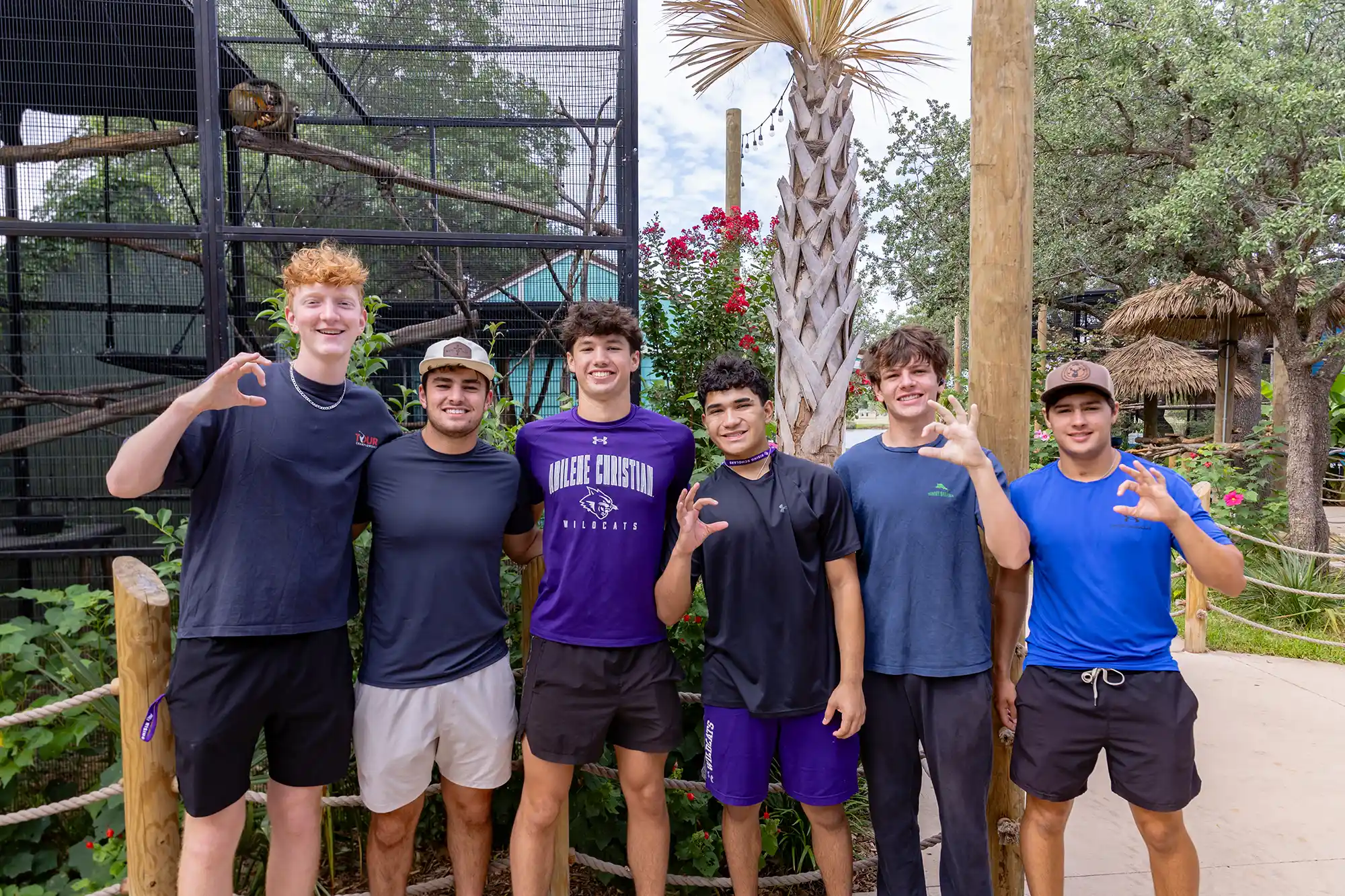 A Rising Scholars group shows their WC hand signs at the Abilene Zoo.