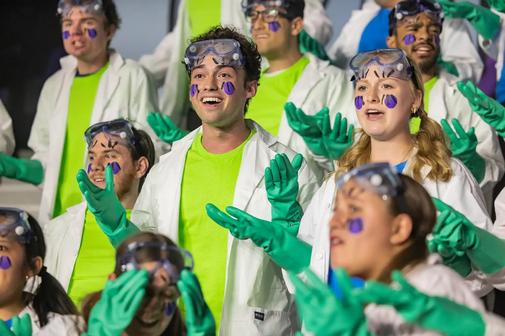 The senior class performs at Sing Song dressed as scientists in lab gear.