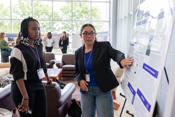Two students discussing a poster presentation